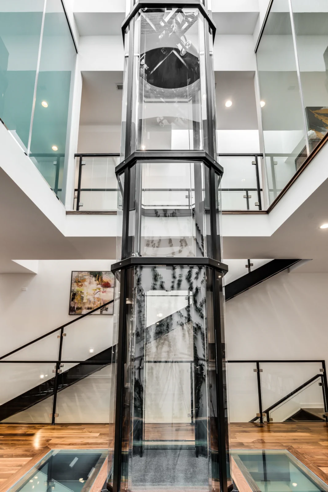 Savaria Vuelift Octagonal glass elevator spanning multiple floors in modern stairwell